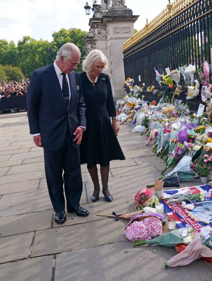 King Charles III and the Queen view tributes left outside Buckingham Palace on Friday