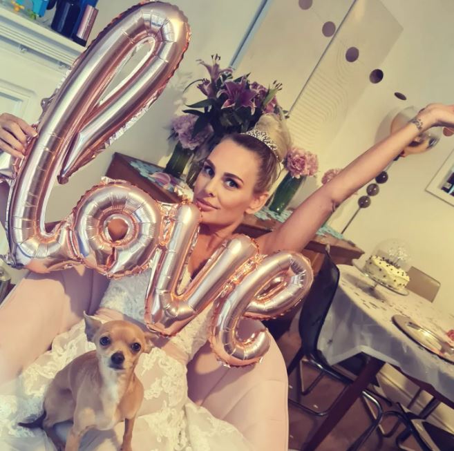 Married At First Sight star Lara, 49, poses with dog Dobby in her home