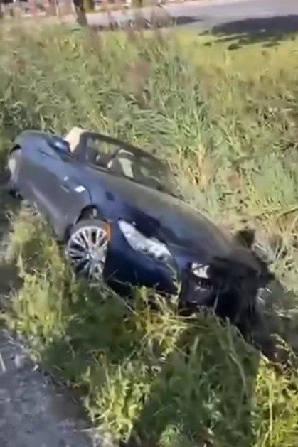 The BMW disappears into the deep ditch, before the person filming rushes over to get more footage