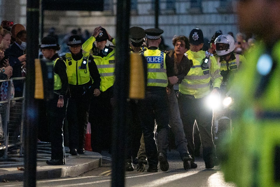 The man is led away by cops as the stunned crowd watches on