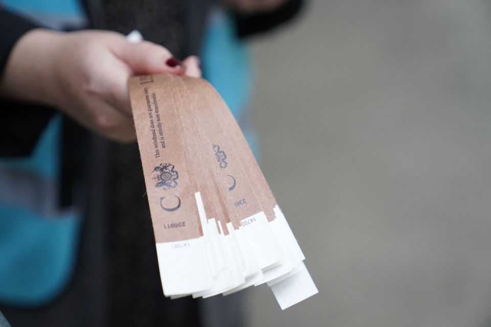 A Marshall holds the treasured wristbands at the end of the queue