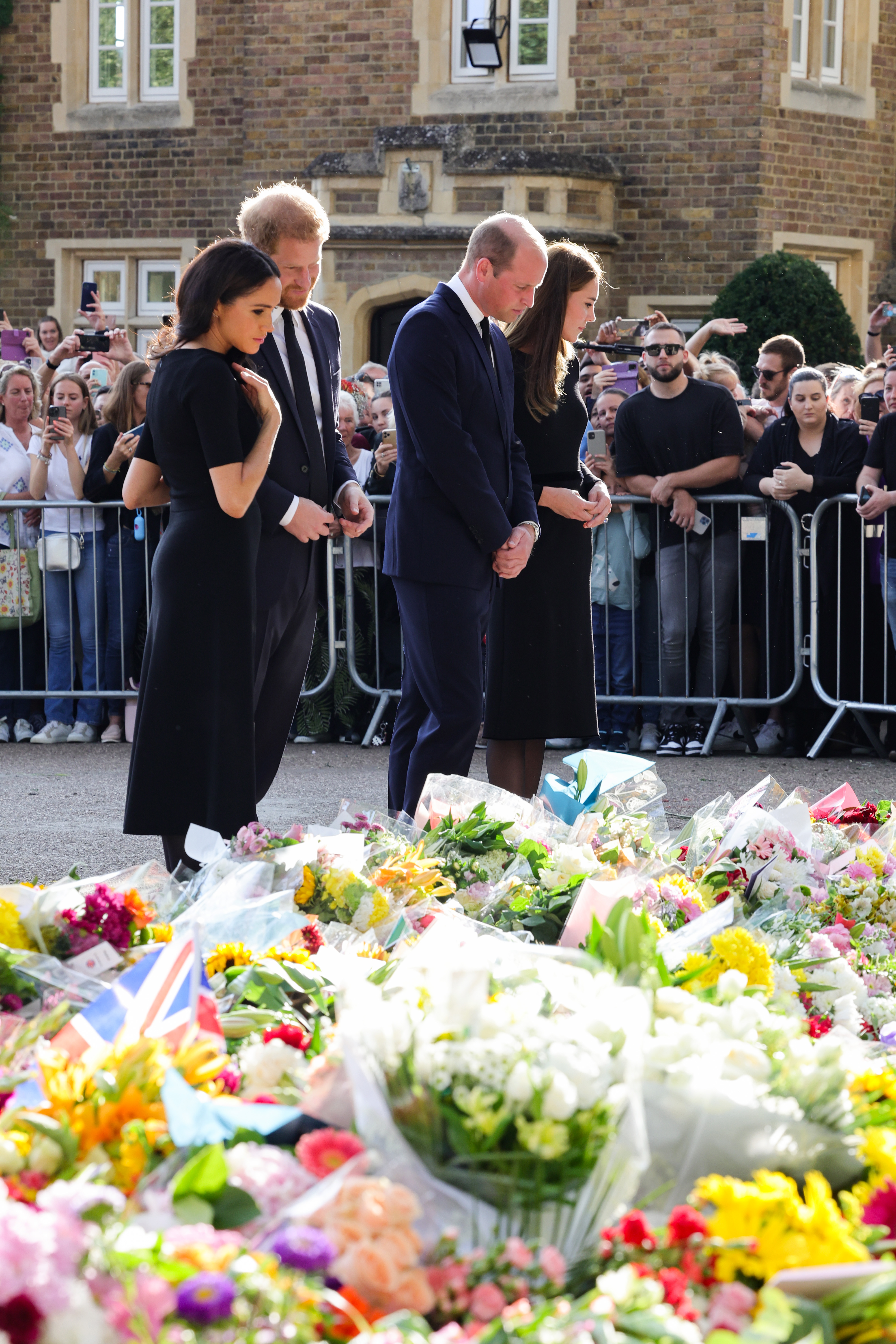 The Prince and Princess of Wales with the Duke and Duchess of Sussex observing flowers