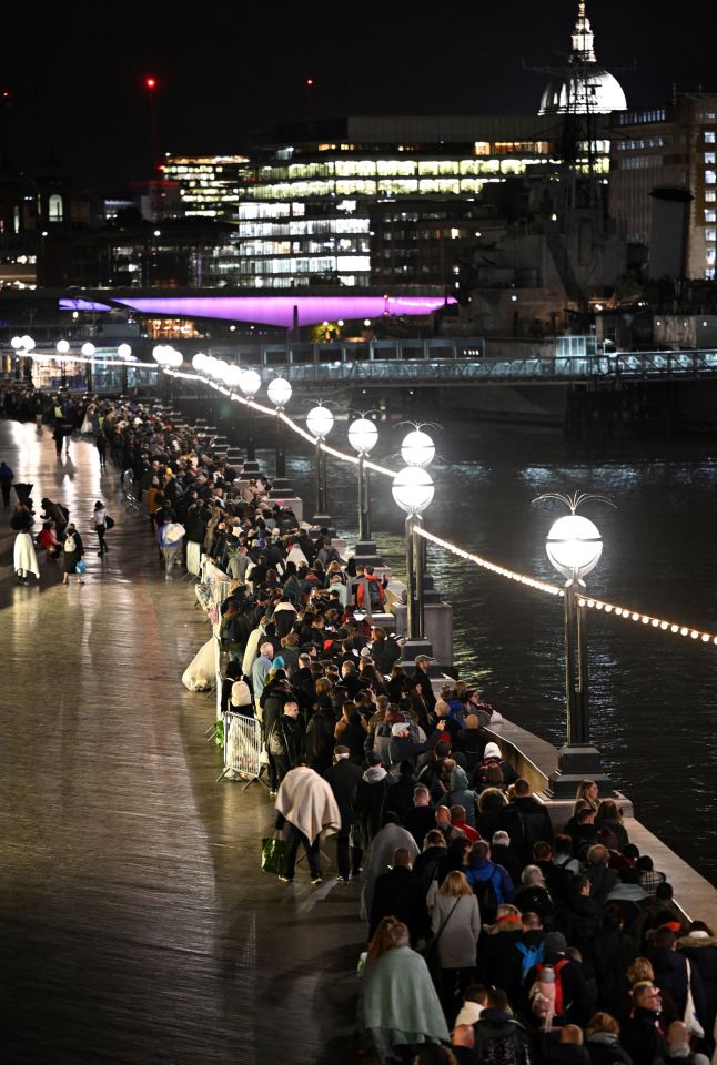 Members of the public wait in the queue in the early hours of the morning, on the South Bank of the River Thames