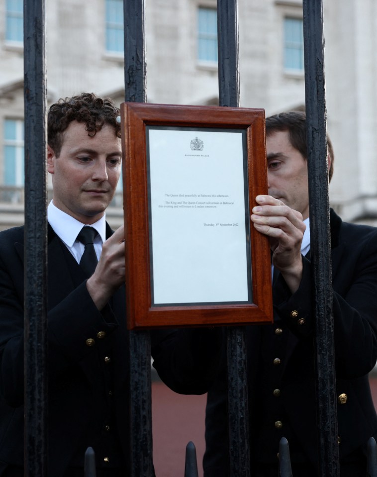 Staff at Buckingham Palace attach the notice of Queen’s death on the main gate