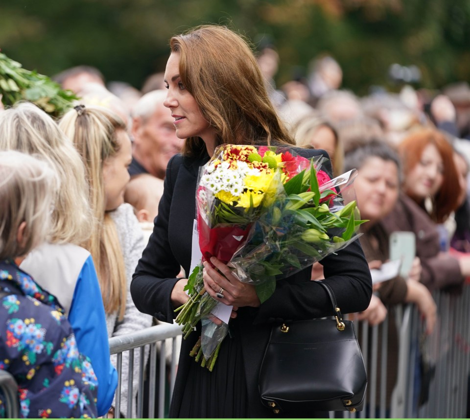 Kate collects a bouquet of flowers as she chats to well-wishers