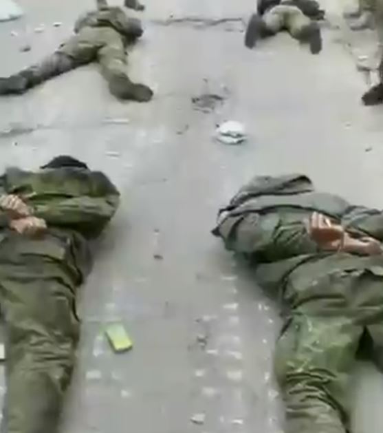 Russian soldiers lying on the road after surrendering