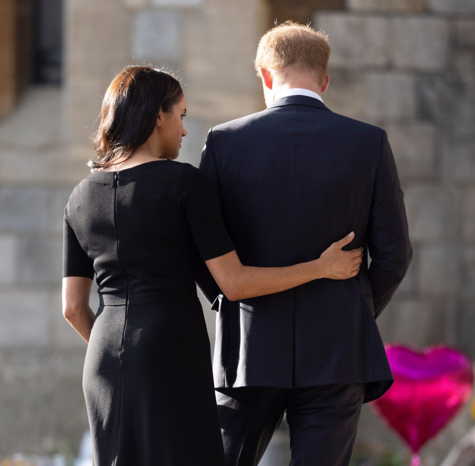 Meghan put a comforting arm around Prince Harry