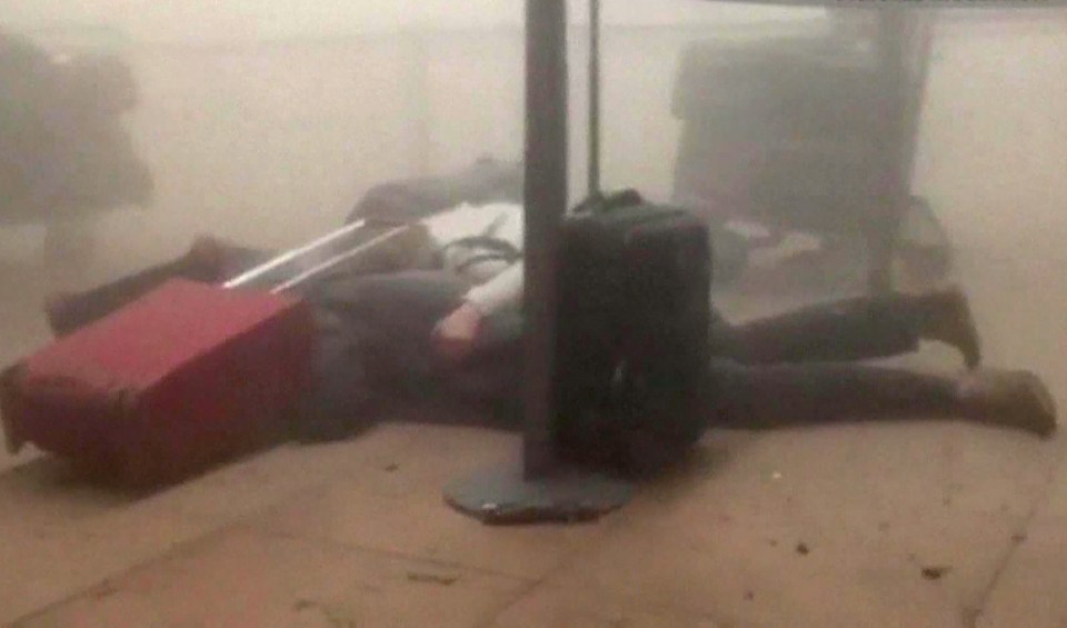 People are seen lying on the floor after a blast ripped through the airport