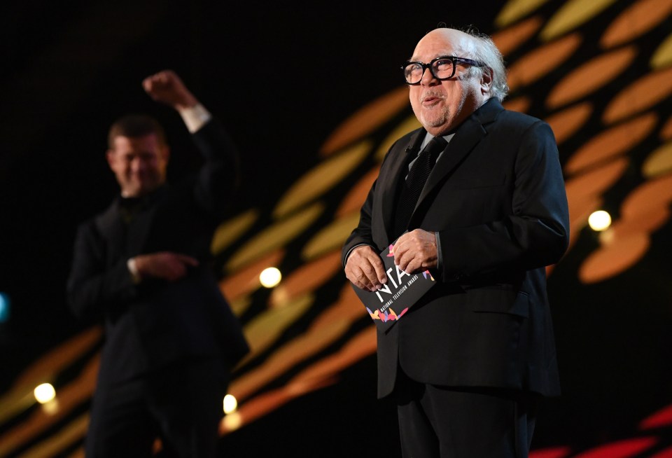 a man in a suit is holding a nia award