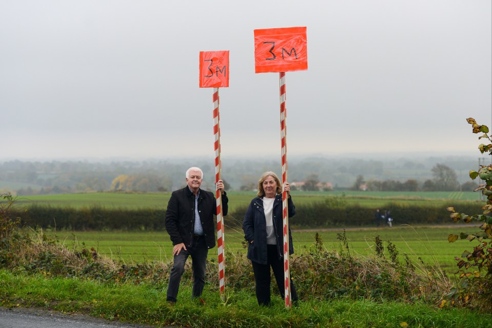 Chris Greaves and Karen Elliott showing how high the fences will be