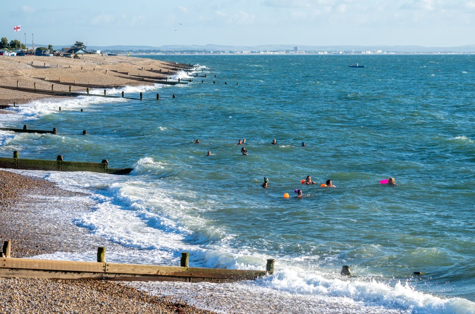 Swimmers from Selsey Seabathing Society taking a dip on a sunny morning in West Sussex