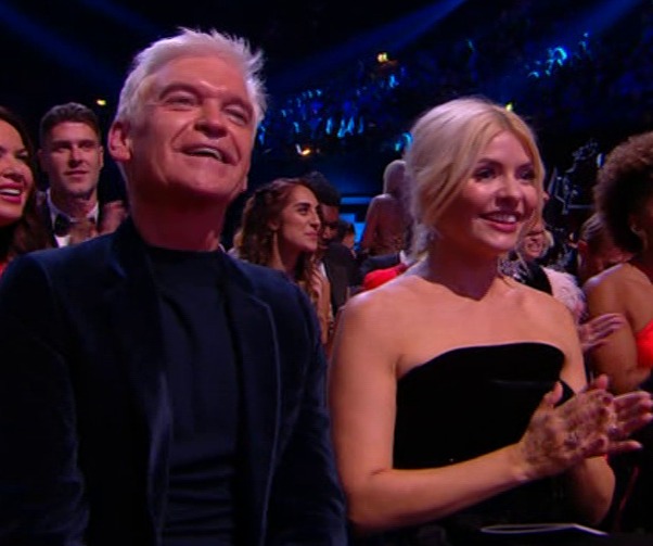 a man and a woman are sitting in the audience at a concert .