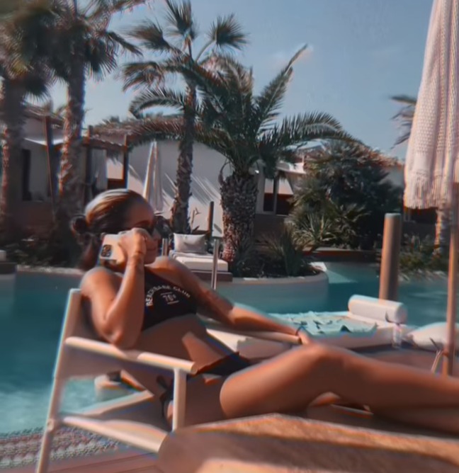 Chelcee shows off her slim figure as she takes a call by the pool