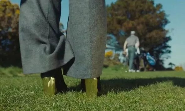 Olivia wore gold heels and a long coat on a golf course