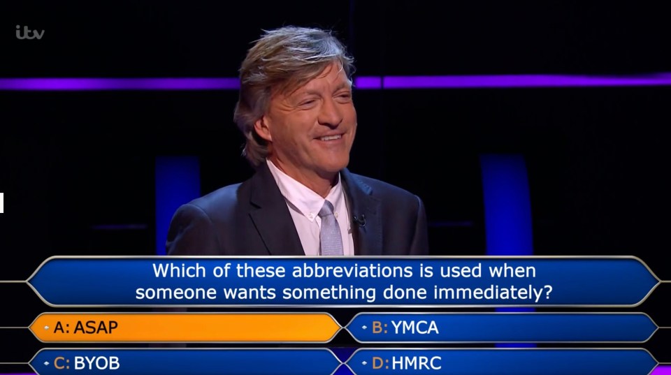 a man stands in front of a who wants to be a millionaire sign