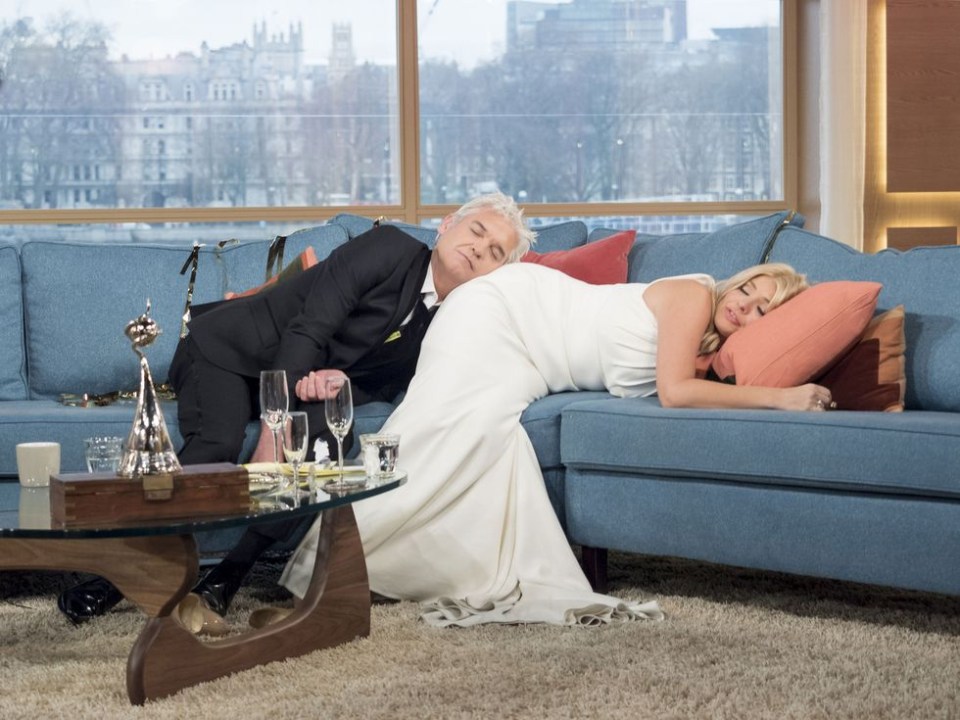 a man in a tuxedo and a woman in a wedding dress are laying on a couch