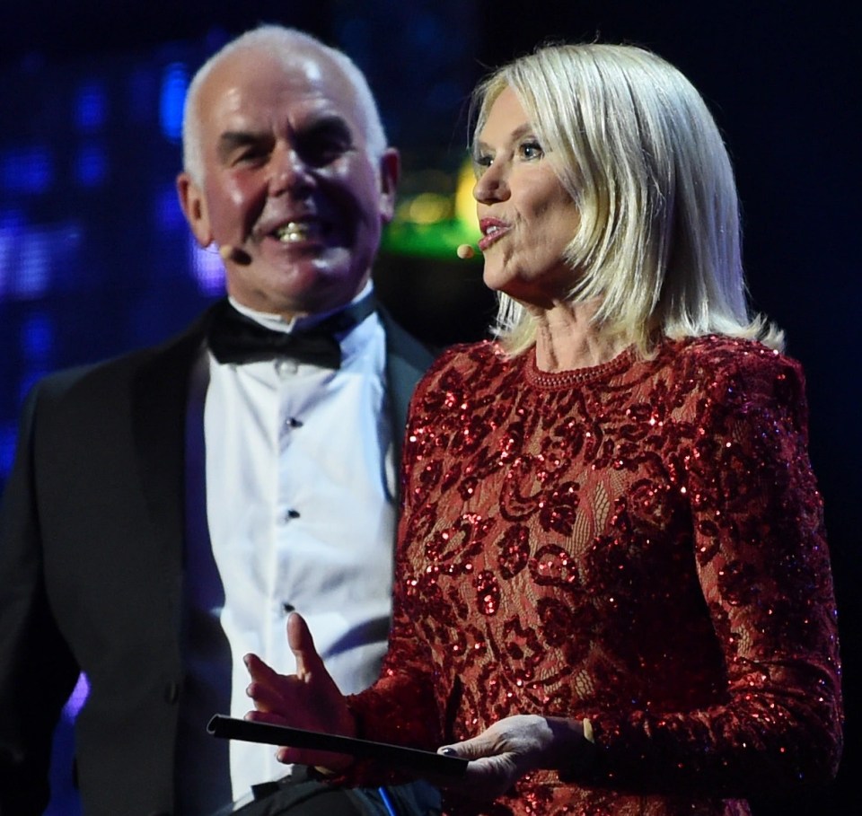 a woman in a red dress stands next to a man in a tuxedo