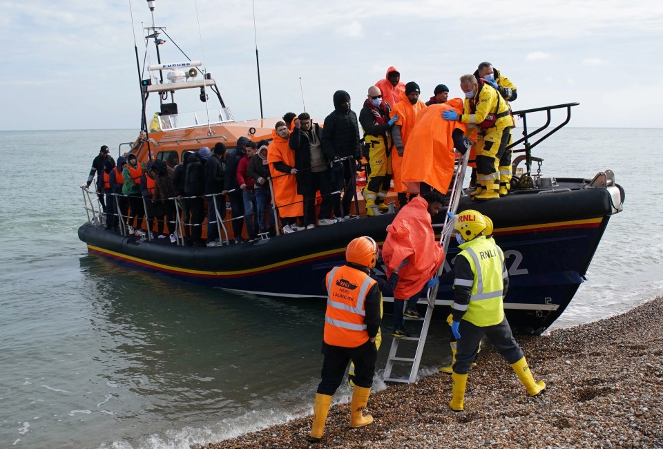 A group of migrants are brought in to Dungeness beach by a lifeboat