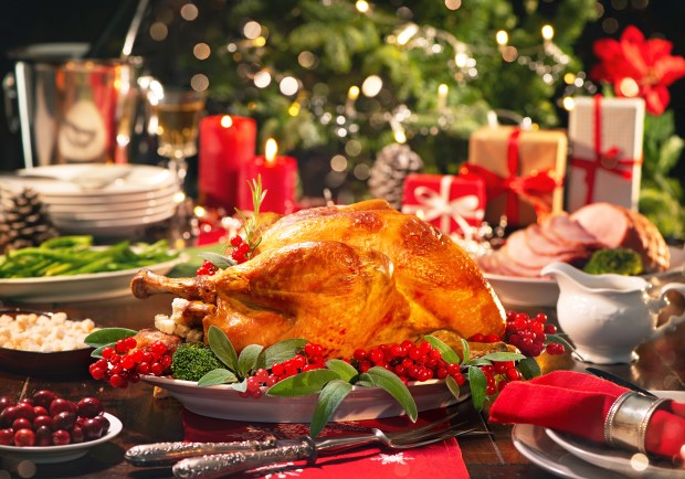 a roasted turkey sits on a plate on a christmas table