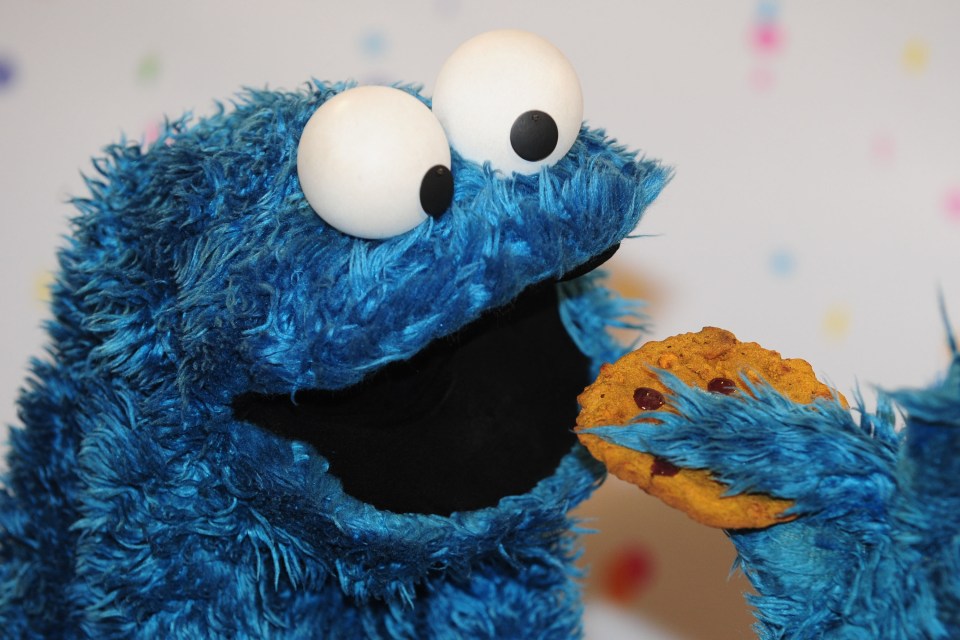 cookie monster from sesame street eating a chocolate chip cookie