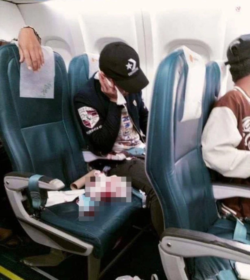 A passenger sits in his seat surrounded by blood-soaked tissues after the shooting