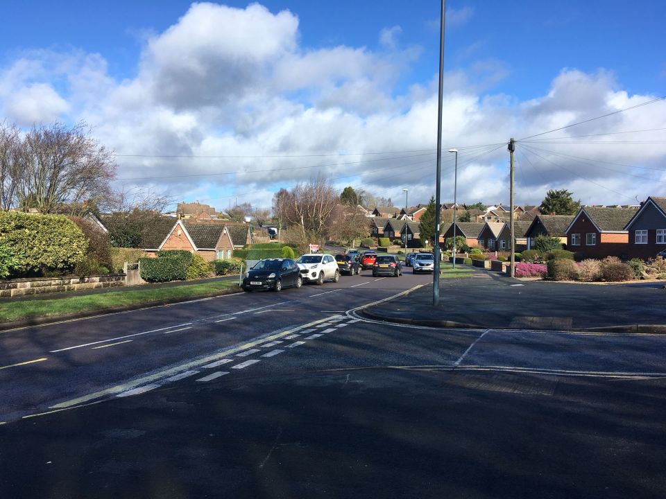 Drivers trying to pass each other next to the parked cars on Birchover Way in Allestree,