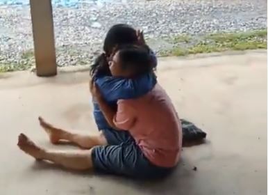 Two horrified bystanders hug outside the daycare centre following the horror attack