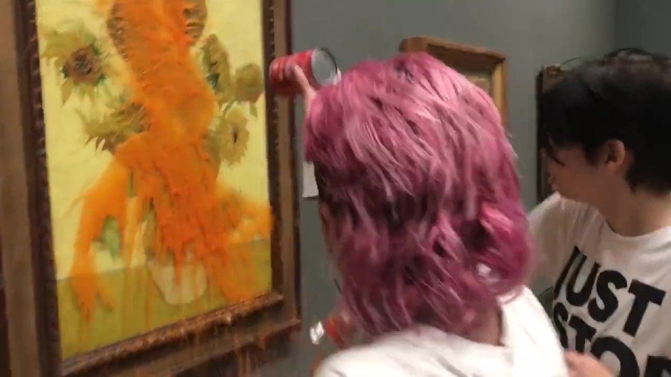 a woman with pink hair is looking at a painting of sunflowers