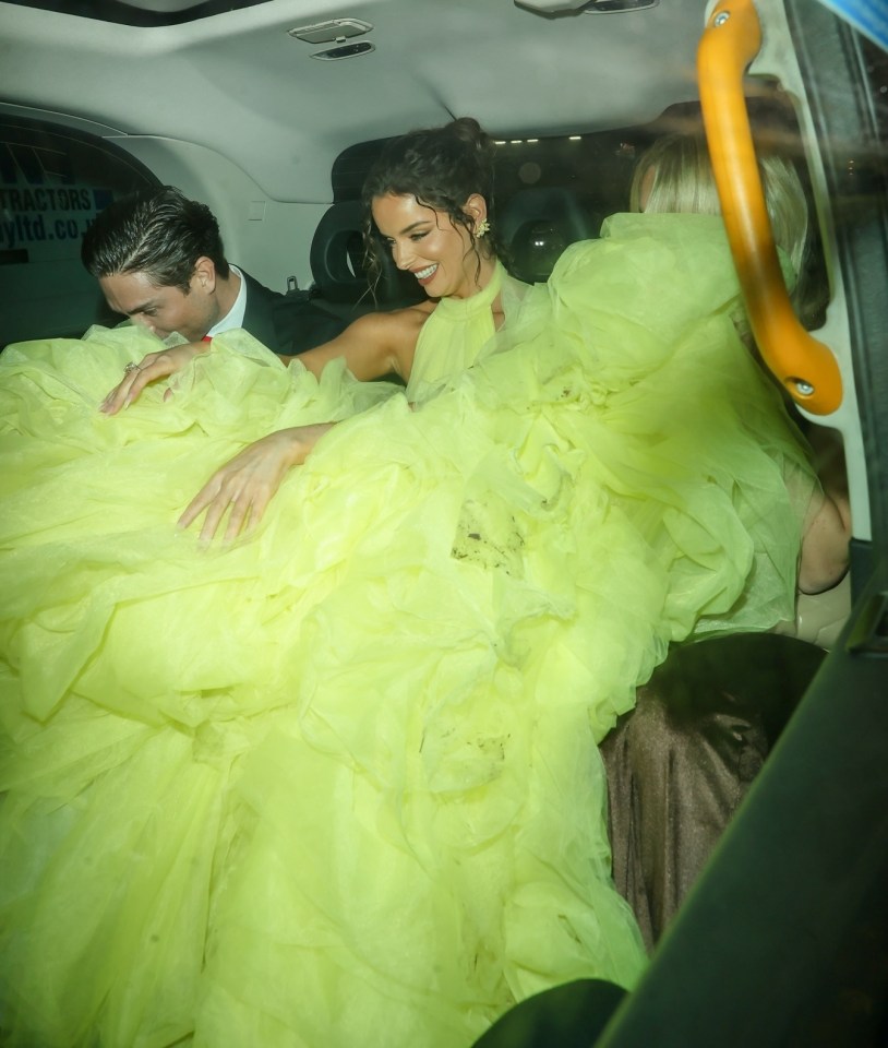 They laughed as Maura appeared to struggle with fitting her dress into the cab