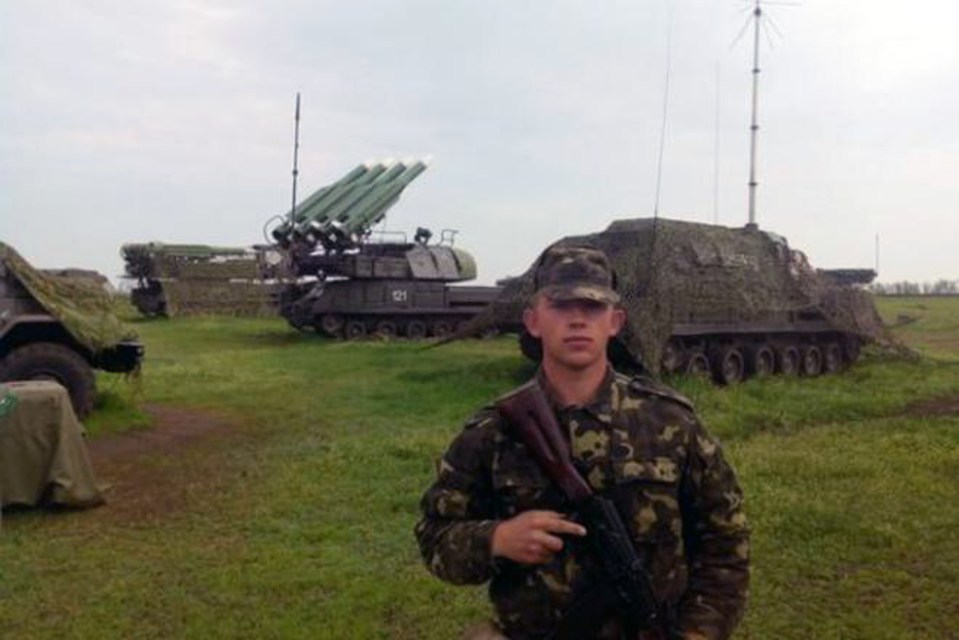 A Donest People's Republic soldier Sergei Pachenko in front of a Buk anti-aircraft missile launcher