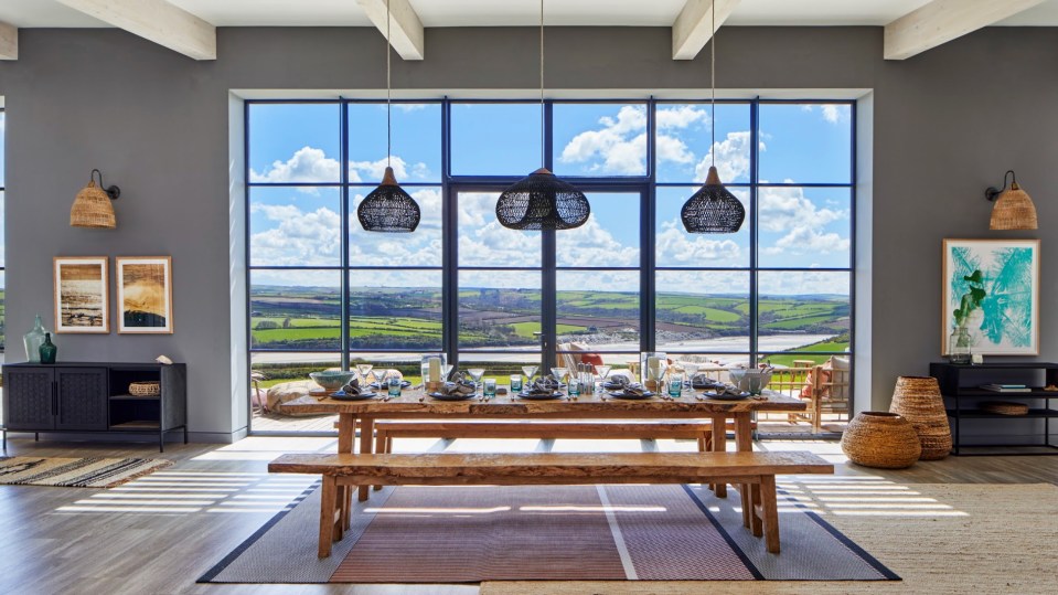 Vast glass and iron windows allow sunlight to flood into a stunning dining room