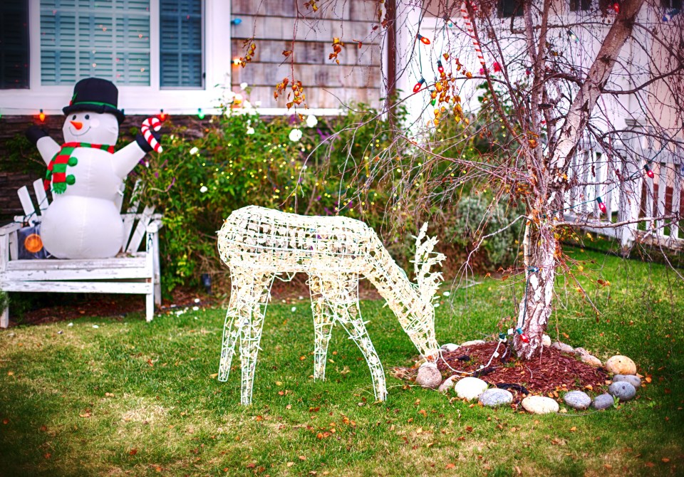 christmas decoration in garden in front of a house with snowman and deer