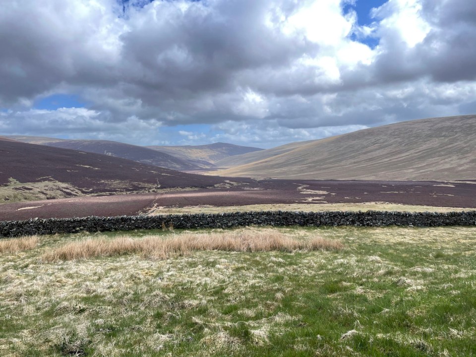 Cars struggle to navigate the winding track up the mountain to Skiddaw House