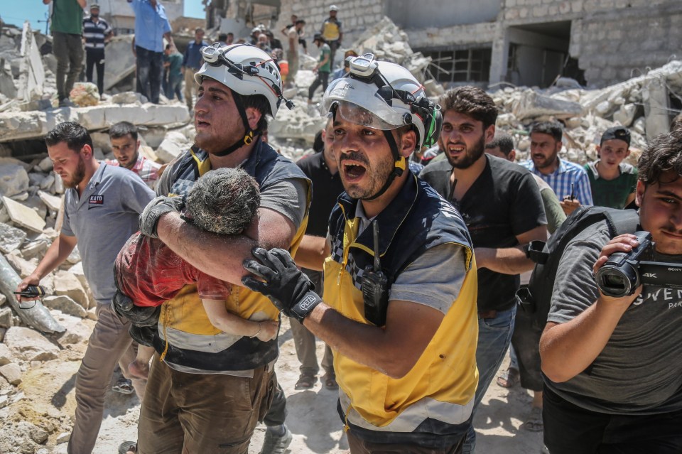 A child being carried from the rubble in Idlib