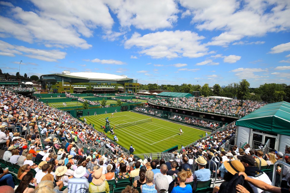 a crowd of people watching a tennis match at wimbledon