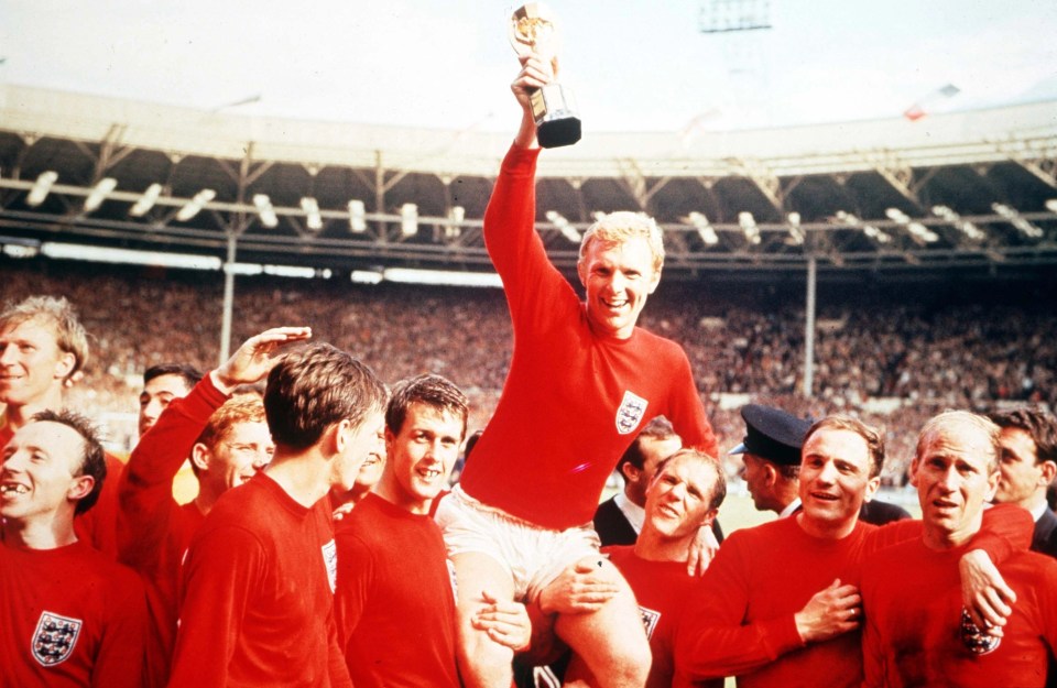 England captain Bobby Moore holds the Jules Rimet World Cup trophy as he sits on his teammate’s shoulders