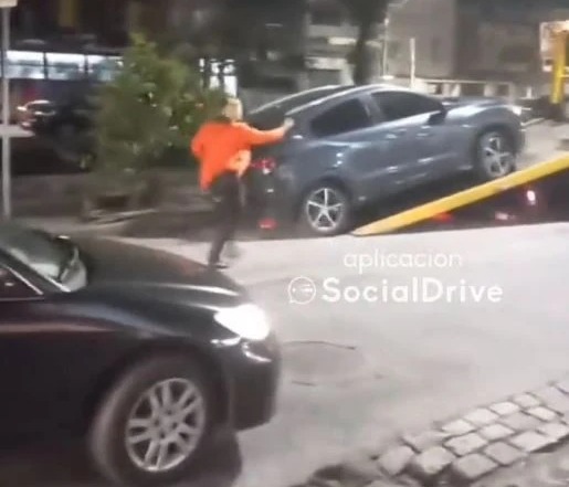 The woman ran back to confront the tow truck drivers