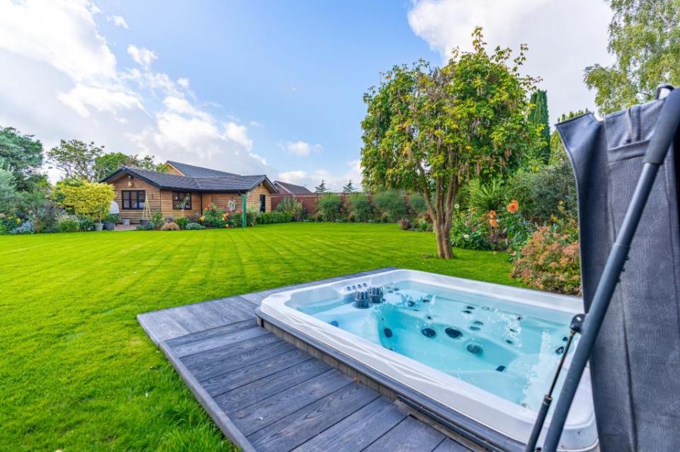 Outside is a summer house and sunken hot tub