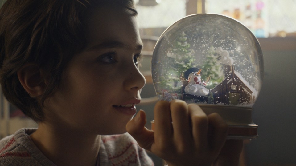 The daughter is captivated by her Snow globe in the ad