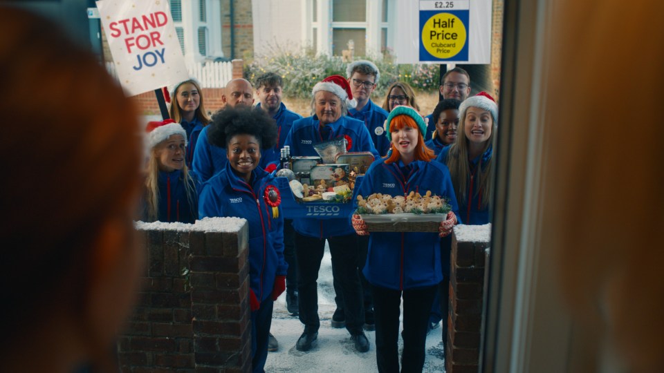 Tesco's advert features carol singers bearing some of the delectable items on offer