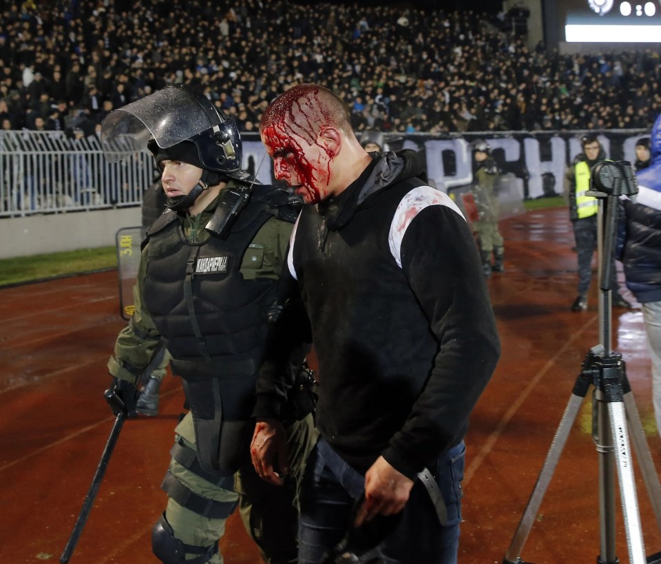 A policeman arrests a supporter after clashes between Red star Belgrade’s and Partizan Belgrade’s hooligans