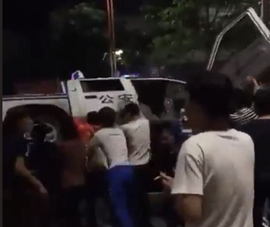 A police car being turned over in the city of Guangzhou