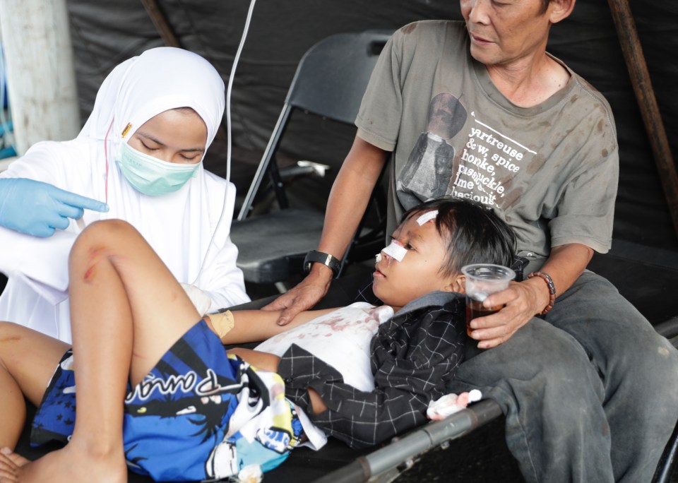 A health worker helps an injured boy