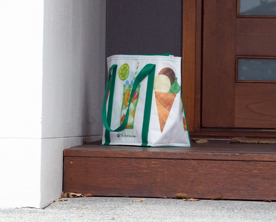 A bag is left with supplies outside the front door of the fancy house