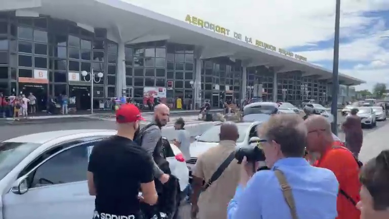 He was flanked by security as he left the airport and entered a parked car