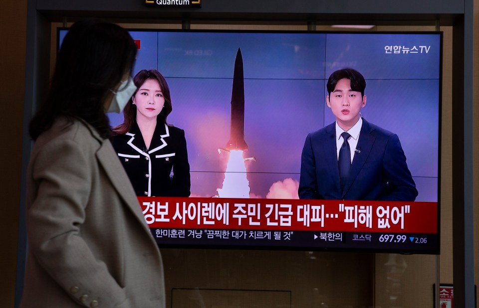 A woman watches the news at a station in Seoul, South Korea about North Korea's rocket launches