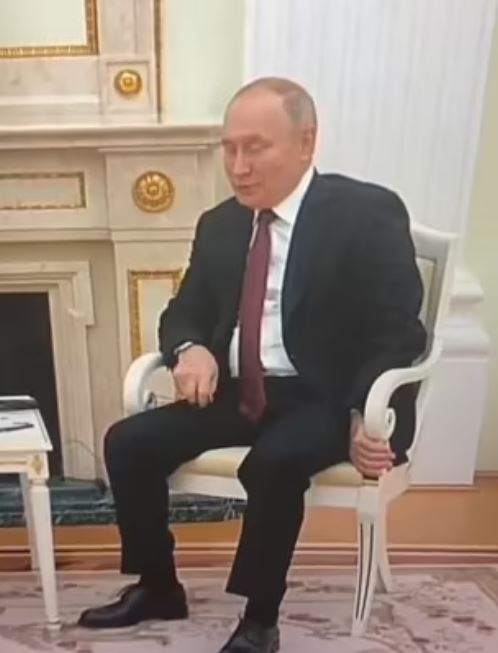 Putin's hand appeared purple as he gripped his chair and fidgeted at a meeting on Wednesday