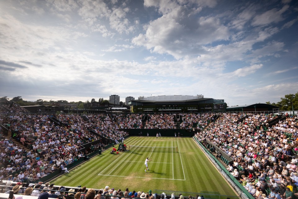 a tennis match is being played in front of a large crowd