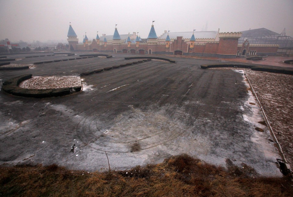 an empty parking lot with a castle in the background