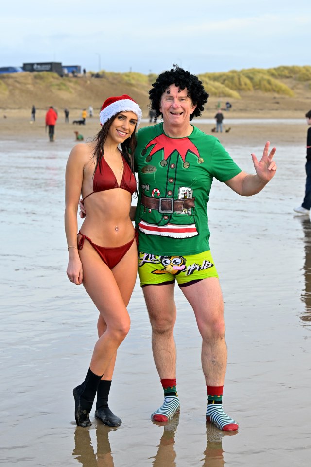 Another woman enjoys a Christmas swim with a man dressed as an elf